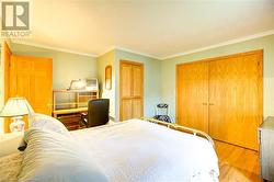 Bedroom with crown molding, a closet, and light hardwood / wood-style flooring - 