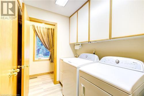 Clothes washing area with cabinets, separate washer and dryer, and light hardwood / wood-style flooring - 3 Maitland Street, Blandford, ON - Indoor Photo Showing Laundry Room