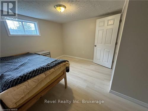 Sitting room featuring a textured ceiling, light hardwood / wood-style flooring, and a wood stove - 3877 Highway 17 E, Mattawa, ON - Indoor