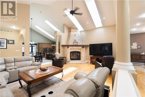 Living room with a fireplace, light hardwood / wood-style floors, high vaulted ceiling, and ceiling fan - 748 Coursol Road, Sturgeon Falls, ON - Indoor Photo Showing Living Room With Fireplace