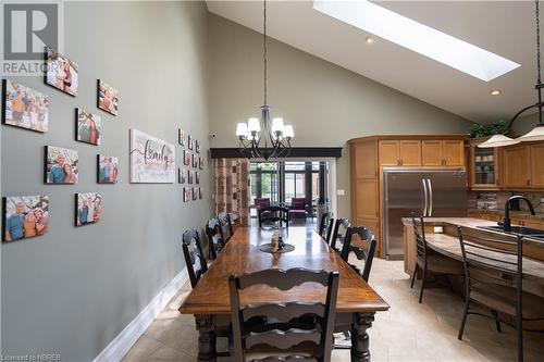 Dining area with a skylight, sink, high vaulted ceiling, a notable chandelier, and light tile patterned flooring - 748 Coursol Road, Sturgeon Falls, ON - Indoor Photo Showing Dining Room