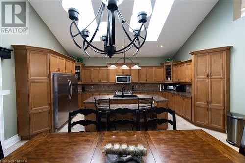 Kitchen featuring pendant lighting, an inviting chandelier, a skylight, appliances with stainless steel finishes, and tasteful backsplash - 748 Coursol Road, Sturgeon Falls, ON - Indoor