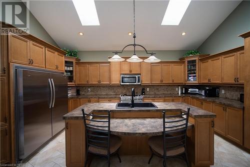 Kitchen with a center island with sink, decorative light fixtures, refrigerator, and lofted ceiling with skylight - 748 Coursol Road, Sturgeon Falls, ON - Indoor Photo Showing Kitchen With Double Sink