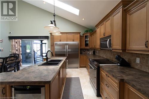 Kitchen featuring a skylight, sink, stainless steel appliances, pendant lighting, and decorative backsplash - 748 Coursol Road, Sturgeon Falls, ON - Indoor Photo Showing Kitchen With Double Sink