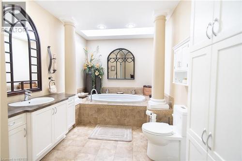 Bathroom featuring toilet, vanity, tiled bath, and ornate columns - 748 Coursol Road, Sturgeon Falls, ON - Indoor Photo Showing Bathroom