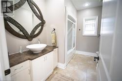 Bathroom featuring tile patterned flooring, vanity, and combined bath / shower with glass door - 