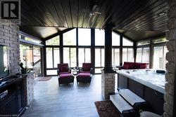 Sunroom with a hot tub, vaulted ceiling, and ceiling fan - 