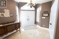 Foyer entrance featuring light tile patterned flooring and a chandelier - 