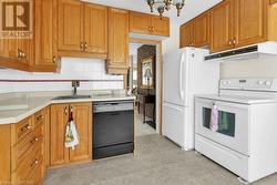 Kitchen featuring backsplash, sink, and white appliances - 