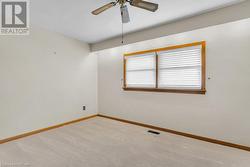 Empty room featuring ceiling fan and light carpet - 