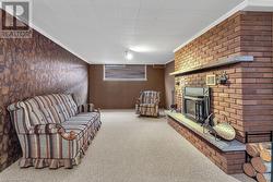 Carpeted living room featuring ornamental molding and a fireplace - 