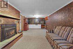 Carpeted living room featuring crown molding and a brick fireplace - 