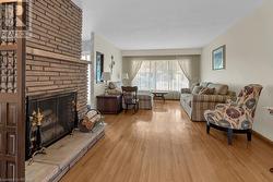 Living room featuring light wood-type flooring and a fireplace - 