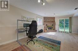 Office space featuring a fireplace, hardwood / wood-style floors, and a textured ceiling - 