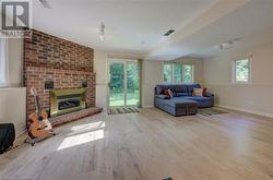 Living room with a fireplace, light hardwood / wood-style flooring, and a textured ceiling - 