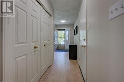 Hall with a textured ceiling and light hardwood / wood-style flooring - 