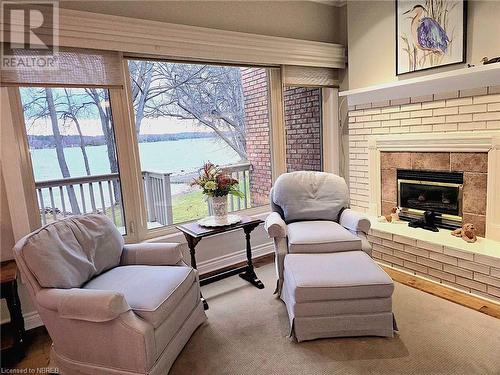 Living area featuring a gas fireplace, and a water view - 555 Main Street S Unit# 5, Callander, ON - Indoor Photo Showing Living Room With Fireplace