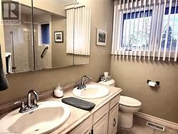 Ensuite Bathroom featuring toilet, double vanity, and tile patterned floors - 