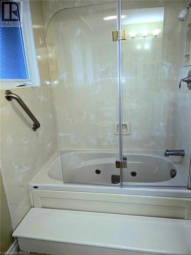 Bathroom featuring shower & jet-tub combination and heated floors - 555 Main Street S Unit# 5, Callander, ON - Indoor Photo Showing Bathroom