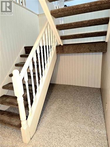 Stairway with carpet floors and wood walls - 555 Main Street S Unit# 5, Callander, ON - Indoor Photo Showing Other Room