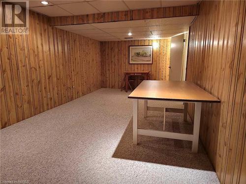 Basement with carpet flooring, a drop ceiling, and wood walls - 555 Main Street S Unit# 5, Callander, ON - Indoor Photo Showing Other Room