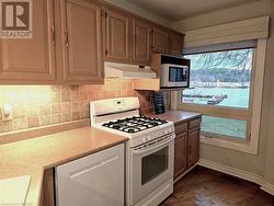 Kitchen featuring water views and a gas stove - 