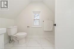 Bathroom with toilet, a textured ceiling, and vaulted ceiling - 