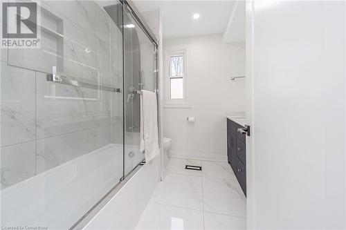 Full bathroom featuring vanity, bath / shower combo with glass door, and toilet - 45 Munroe Street, Hamilton, ON - Indoor Photo Showing Bathroom