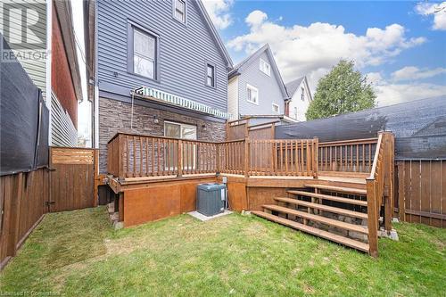 Rear view of house featuring a yard, central AC, and a wooden deck - 45 Munroe Street, Hamilton, ON - Outdoor With Deck Patio Veranda