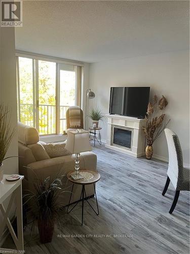 504 - 8111 Forest Glen Drive, Niagara Falls (208 - Mt. Carmel), ON - Indoor Photo Showing Living Room With Fireplace