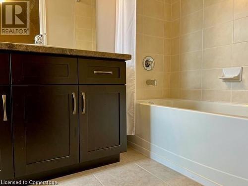 Bathroom with tile patterned floors and shower / bath combination with curtain - 683 Robert Ferrie Drive, Kitchener, ON - Indoor Photo Showing Bathroom