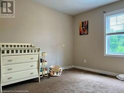 Bedroom featuring carpet floors and a nursery area - 