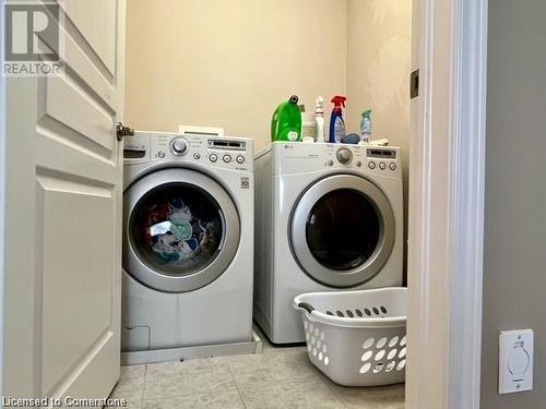 Laundry area featuring washer and dryer and light tile patterned flooring - 683 Robert Ferrie Drive, Kitchener, ON - Indoor Photo Showing Laundry Room