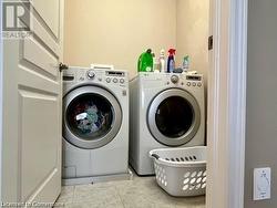 Laundry area featuring washer and dryer and light tile patterned flooring - 