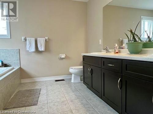 Bathroom featuring tile patterned floors, vanity, toilet, and tiled bath - 683 Robert Ferrie Drive, Kitchener, ON - Indoor Photo Showing Bathroom