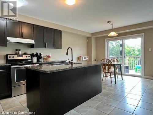 Kitchen featuring sink, pendant lighting, electric range, a center island with sink, and stone countertops - 683 Robert Ferrie Drive, Kitchener, ON - Indoor Photo Showing Kitchen With Double Sink With Upgraded Kitchen