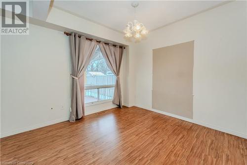 Spare room with a notable chandelier and wood-type flooring - 10 Fenwick Court, Kitchener, ON 