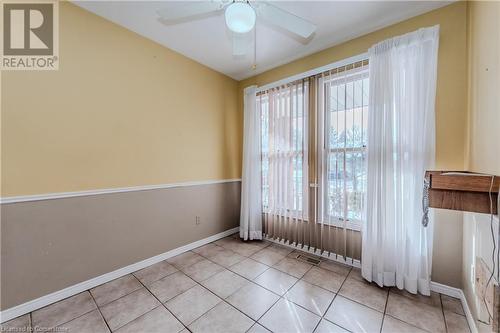 Empty room with ceiling fan, a healthy amount of sunlight, and light tile patterned flooring - 10 Fenwick Court, Kitchener, ON 