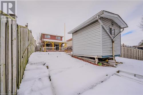 Yard layered in snow with a porch - 10 Fenwick Court, Kitchener, ON 