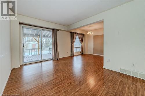 Empty room featuring hardwood / wood-style floors and an inviting chandelier - 10 Fenwick Court, Kitchener, ON 