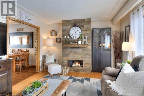 Living room with a tile fireplace, ornamental molding, and light wood-type flooring - 19 Halifax Drive, Kitchener, ON - Indoor Photo Showing Living Room With Fireplace