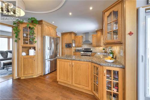 Kitchen featuring sink, wall chimney exhaust hood, dark hardwood / wood-style floors, decorative backsplash, and stainless steel appliances - 19 Halifax Drive, Kitchener, ON - Indoor Photo Showing Kitchen