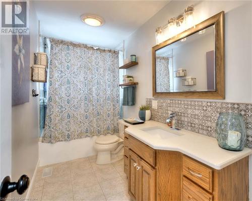 Full bathroom with shower / bath combo, vanity, tile patterned flooring, decorative backsplash, and toilet - 19 Halifax Drive, Kitchener, ON - Indoor Photo Showing Bathroom