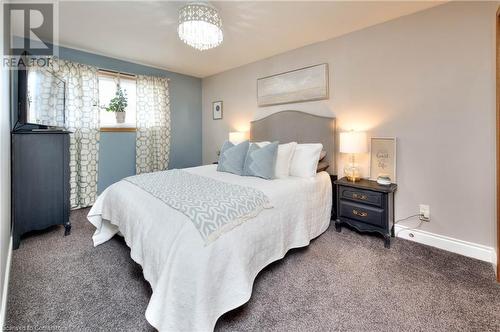 Bedroom featuring dark carpet and a notable chandelier - 19 Halifax Drive, Kitchener, ON - Indoor Photo Showing Bedroom