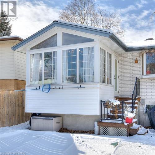 View of snow covered exterior featuring a sunroom - 19 Halifax Drive, Kitchener, ON - Outdoor With Exterior