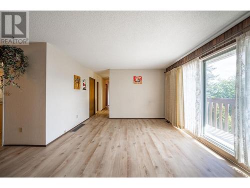 living room w/new laminate flooring - 6477 Southwind Road, Vernon, BC - Indoor Photo Showing Other Room