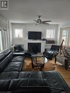 Living room with hardwood / wood-style flooring, a wealth of natural light, and ceiling fan - 