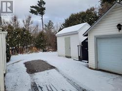 Snowy yard featuring an outdoor structure and a garage - 