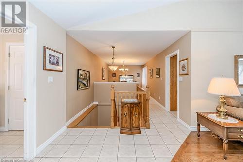 Hallway featuring light tile patterned floors and an inviting chandelier - 64 Cottonwood Crescent, Cambridge, ON - Indoor