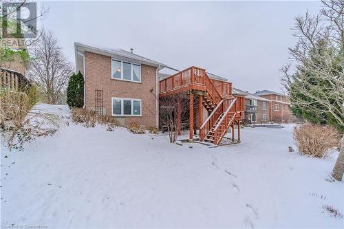 Snow covered rear of property with a wooden deck - 64 Cottonwood Crescent, Cambridge, ON - Outdoor